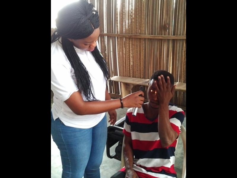 Dr Ogechi Obidike (Optometrist) of Motus Health Initiative, screening a beneficiary at the Aboki estate Lekki Free Medical outreach.